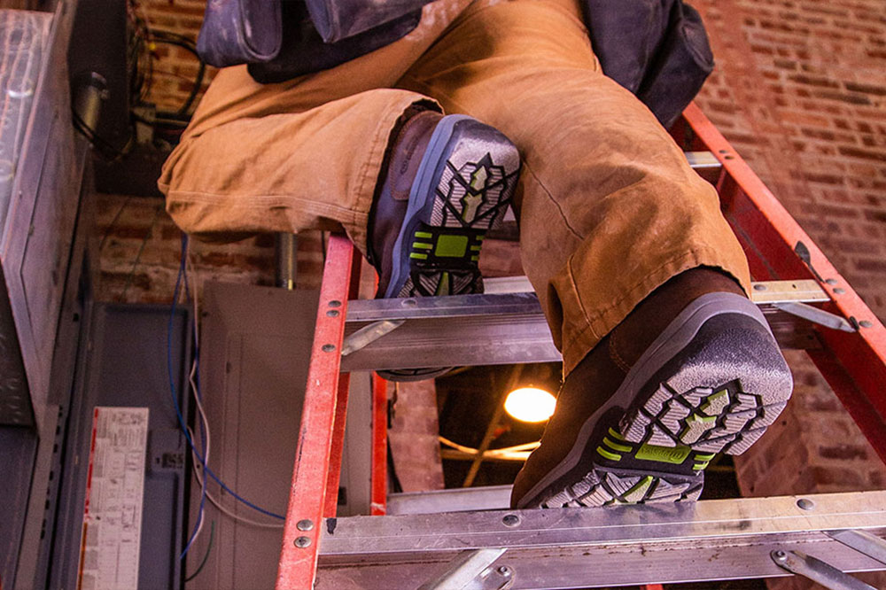 A man wearing the Fabricator 6" Waterproof Comp Toe Hiker boots in brown.